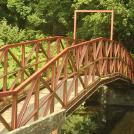 a red bridge into a forest