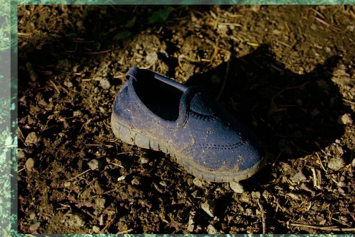 A lost shoe on dirt.
